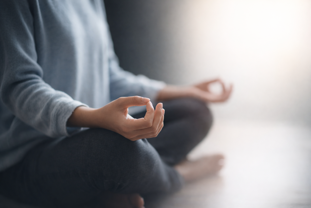 Person sitting cross-legged in a calm posture, practicing mindfulness and emotional balance
